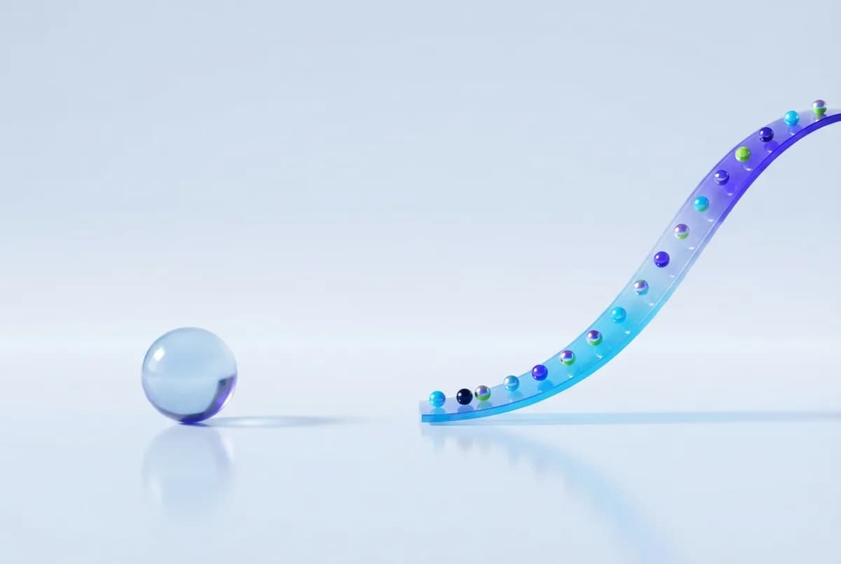 A single glass sphere beside a long rising ribbon of many small spheres